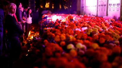People meet in front of a floral offering for the victims who died in the September 19 earthquake as part of Day of the Dead celebrations at Mexico park in Mexico City, Mexico. Edgard Garrido / Reuters