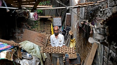 A potter lays out earthen lamps on a tray in New Delhi. AFP