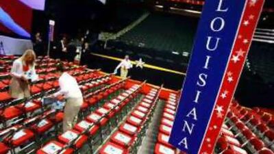 Workers place seating packets on the chairs of the Louisiana delegation yesterday.