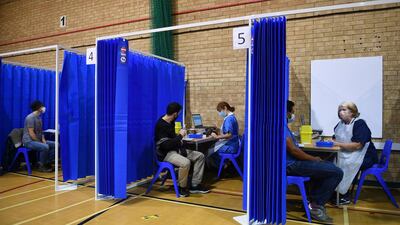 Medical staff in booths prepare to administer the Pfizer-BioNTech Covid-19 vaccine at a vaccination centre in Cardiff, Wales on December 8, 2020. AP