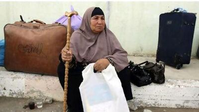 A Palestinian woman waits to cross into Egypt on Thursday. With Egypt lifting border restrictions, the passage will be easier.