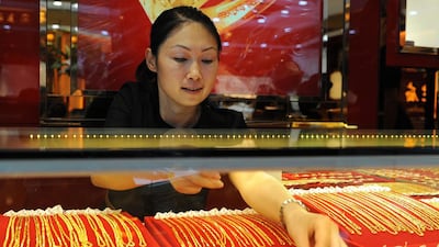 Gold trading volumes for the Shanghai Gold Exchange were up nearly 22 per cent in September. A woman arranges gold jewellery on display at a shop in east China’s Anhui province. AFP