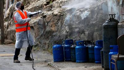 A Palestinian worker sprays disinfectant in the West Bank city of Nablus. AP Photo