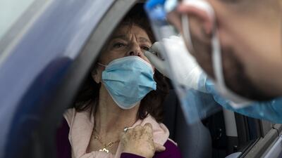 A medical worker for the Greek National Public Health Organisation takes a sample from a driver at a Covid-19 drive-through testing station, at Menidi suburb, near Athens, Greece. Bloomberg