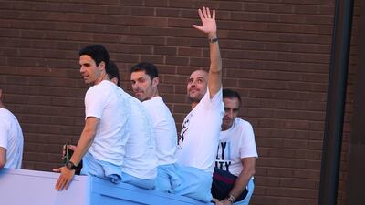 Manchester City's manager Pep Guardiola, second right, waves during a bus parade to celebrate their English Premier League title win. Nigel Roddis / EPA