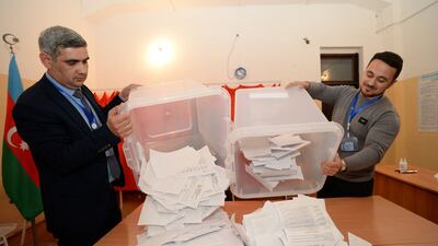 Electoral commission workers empty ballot boxes to count votes in the Azerbaijani presidential election at a polling station in Baku. AFP