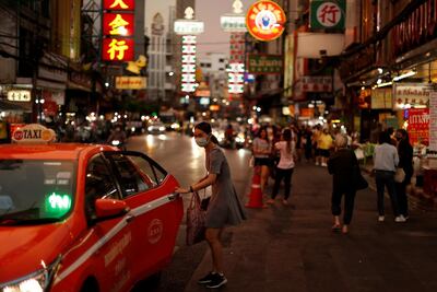A woman wearing a protective face mask enters a taxi in Chinatown, in Bangkok, Thailand, on May 3, 2020. Reuters