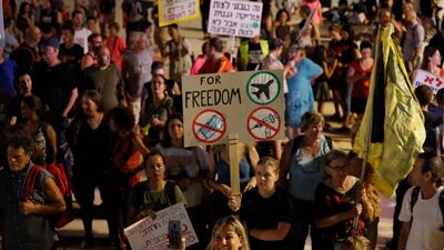 Israelis hold placards at a rally in Tel Aviv on July 31, 2021 denouncing the government’s renewed restrictions to combat Covid-19.