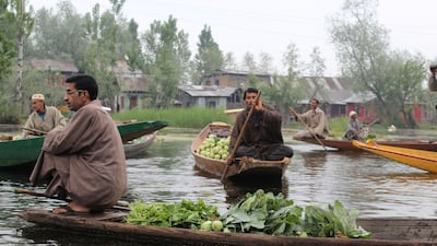 Farmers can typically be spotted squatting at the edge of their wooden shikara boats at the fruit and vegetable market on Dal Lake. Priti Salian for The National
