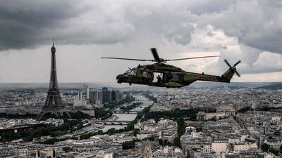 An NH90 "CAIMAN" helicopter flies over the Eiffel Tower and the Seine river during a practice session prior to July 14's Bastille Day Parade in Paris.