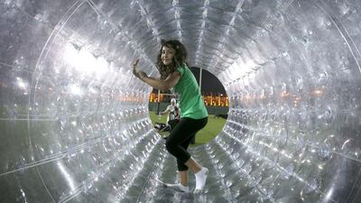 Aya Atmaca, 8, plays in a giant plastic hamster wheel, one of a string of activities, at Kidsfest in Abu Dhabi yesterday. Silvia Razgova / The National
