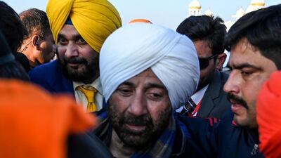 Security personnel escort Indian Bollywood actor Sunny Deol, centre, and Indian politician and former cricketer Navjot Singh Sidhu, left, as they visit the Shrine of Baba Guru Nanak Dev at Gurdwara Darbar Sahib in Kartarpur, near the Indian border, on November 9, 2019. AFP