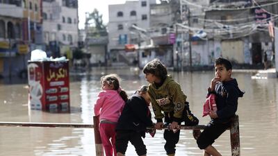 Palestinian children play on a flooded street following heavy rains in Jabalia refugee camp in northern Gaza strip. AFP