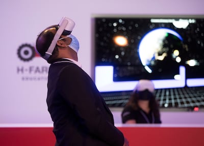 A visitor wears a virtual reality headset for a tour of the RewirEd summit at Expo 2020 Dubai. Ruel Pableo for The National