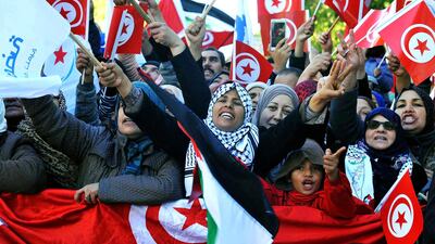Tunisian people march with national flags during a rally to mark seven years since revolution in Tunis, Tunisia, Sunday, Jan. 14, 2018. AP Photo / Hassene Dridi