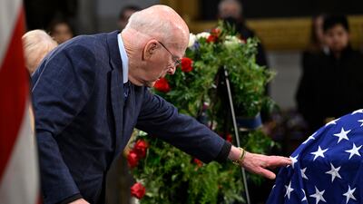 Former senator Patrick Leahy of Vermont touches the American flag draped over the coffin. AP