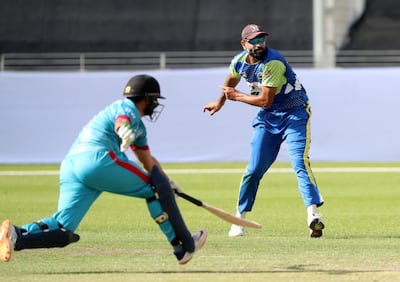 Fujairah skipper Ahmed Raza tries to run out a Dubai's Omer Farooq in their Emirates D20 match. Chris Whiteoak / The National