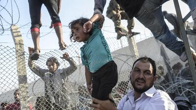 A Syrian child fleeing the war is lifted over border fences to enter Turkish territory illegally, near the Turkish border crossing at Akcakale in Sanliurfa province on June 14. Agence France-Presse photographer Bulent Kilic was honoured on Saturday at photojournalism’s biggest annual festival for dramatic images of refugees fleeing across the Turkish border. Kilic, 35, won the Visa d’Or for News, the most prestigious award handed out at the “Visa Pour L’Image” festival in Perpignan, southwestern France. Bulent Kilic / AFP
