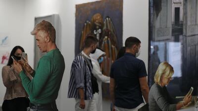 Visitors look at a cut-out artwork by American artist Michelangelo Pistoletto during Art Dubai 2020 at Dubai International Financial Centre. EPA