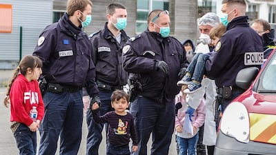 French Gendarmes and police assist migrants, including five children and a baby, who tried to reach England by crossing the Channel, and who were rescued off the French port city of Calais on May 16. Bernard Barron / AFP