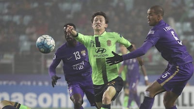 Lee Jae-sung, centre, of Jeonbuk Hyundai Motors, fights for the ball against Ahmed Barman and Ismail Ahmed, right, of Al Ain. Choe Young-soo / AP Photo