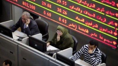 Financial traders work at their desks beneath a screen displaying financial data inside the Egyptian stock exchange in Cairo, Egypt, on Tuesday, Nov. 22, 2011. Egypt's benchmark dollar bonds slumped, sending the yield to the highest level since January, after concessions made by the country's military rulers were rejected by protesters demanding a civilian government. Photographer: Shawn Baldwin/Bloomberg *** Local Caption *** 942908.jpg