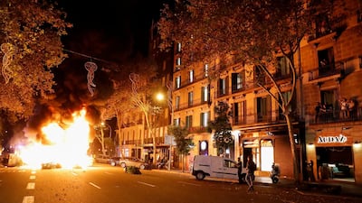 People look at a burning barricade during a protest against the closure of bars and gyms. Reuters