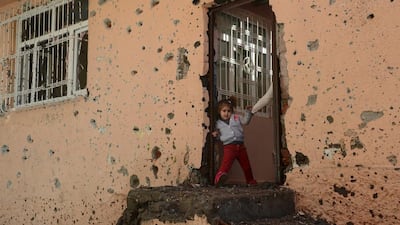 A girl stands at the entrance of a damaged house in the Sur district in Diyarbakir. A policeman was killed on December 9, by sniper fire as he tried to defuse an explosive device in the Sur district of Diyarbakir province, which has been under military curfew for eight days. Ilyas Akengin / AFP
