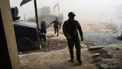 Members of the Iraqi Counter Terrorism Service take shelter after a mortar shell hit nearby near the village of Bazwaya, on the eastern edges of Mosul, as they advance towards Iraq's last remaining ISIL stronghold on October 31, 2016. Bulent Kilic/AFP