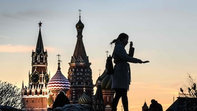 A tourist takes a selfie in front of the Kremlin and St Basil Cathedral at sunset in Moscow, Russia. AFP