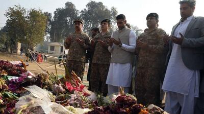Amir Khan prays at the memorial at the army-run school in Peshawar, Pakistan on Monday where 148 people were murdered by the Taliban on December 16. A Majeed / AFP
