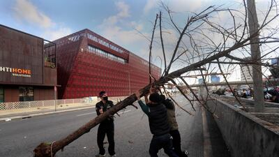 Protesters move a tree to block a main highway, during a protest in the town of Jal el-Dib, north of Beirut. AP Photo