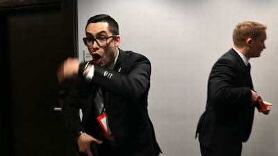 Agents draw their guns after loud bangs were heard during the White House Correspondents' dinner at the Washington Hilton in Washington, DC, on April 25, 2026. President Trump is attending the annual gala of the political press for the first time while in office. (Photo by Mandel NGAN / AFP)