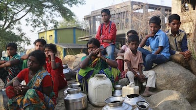 Crowds wait to fill their vessels with water at a communal tap in Kukse Borivali north-east of Mumbai this past Tuesday. Running water is shut off for three days a week in parts of Maharashtra. Rafiq Maqbool / AP Photo