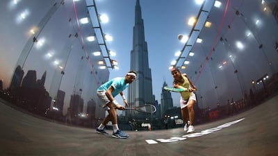 Nicol David, right, and Mohamed Elshorbagy play squash with the Burj Khalifa in the background. Courtesy UAE Squash Association