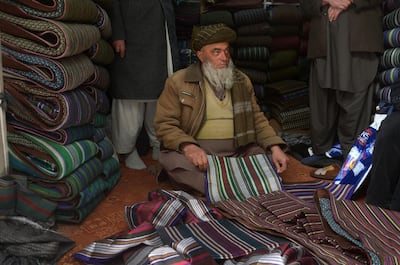 An Afghan shopkeeper and provincial contractor of Zarif Design House shows original fabric to made a chapan (coat) at his shop in Mazar-i-Sharif. Farshad Usyan/ AFP