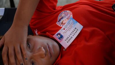 An attendee rests on a stretcher after she fell ill with suspected food poisoning from meals served during a birthday celebration in honour of former Philippine first lady Imelda Marcos, at a sports arena in Manila on July 3, 2019. Over 200 guests fell ill with suspected food poisoning on July 3 after a meal at a birthday party for 90-year-old Imelda Marcos, the notorious former first lady of the Philippines. / AFP / Ted ALJIBE