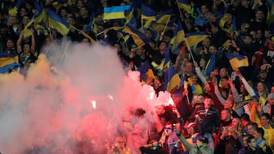 Ukraine fans light flares inside the stadium after Roman Yaremchuk scores. Reuters