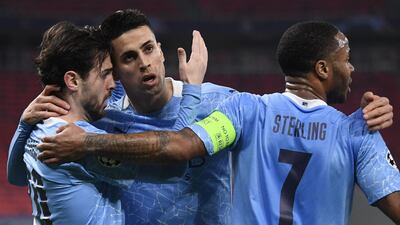 Manchester City's Portuguese midfielder Bernardo Silva (L) celebrates with Joao Cancelo (C) and Raheem Sterling after scoring his team's first goal during the UEFA Champions League match against Borussia Moenchengladbach. AFP