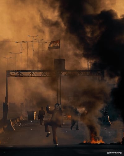 Joaquin Phoenix's Joker dances beneath a plume of black smoke from a burning tyre. Courtesy Ahmad Shwqy