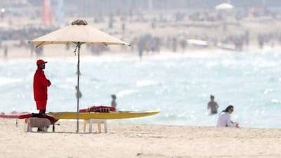 A lifeguard watches beachgoers at Jumeirah Beach Residences beach.
