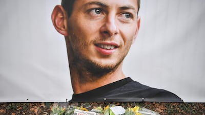 Flowers and candles are left with the French sports daily newspaper 'L'Equipe' next to a portrait of Sala in front of the entrance of the FC Nantes football club training center La Joneliere in La Chapelle-sur-Erdre, France. AFP