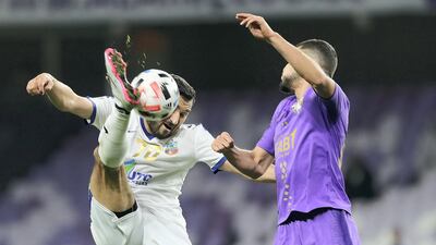 Al Ain's Jamal Maroof fights for the ball with Murod Khalmukhamedov of Bunyodkor. Chris Whiteoak / The National
