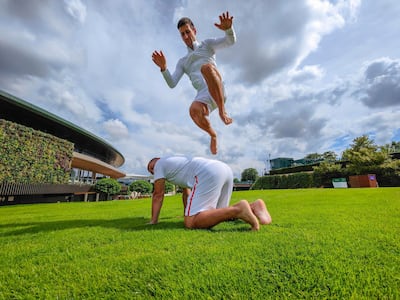 Novak Djokovic jumps over his physiotherapist Ulises Badio at The All England Club in London as he prepares for Wimbledon. PA