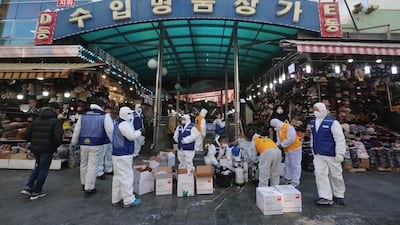 Workers wearing protective gear prepare to spray disinfectant as a precaution against a new coronavirus at Namdaemun Market in Seoul, South Korea. AP Photo