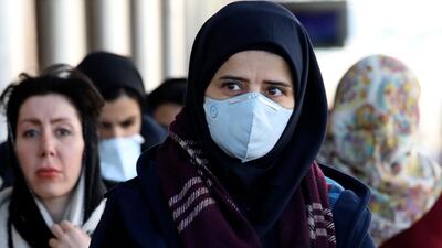 People wearing face masks walk on a sidewalk in downtown Tehran. AP