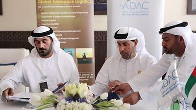 Ali Majed Al Mansoori, the chairman of Adac, centre, and GAL's chief executive, Hassan Yousuf Al Awadhi sign the agreement at the Abu Dhabi Air Expo yesterday. Fatima Al Marzooqi / The National