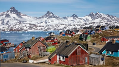 Snow-covered mountains rise above the harbour and town of Tasiilaq, Greenland. Reuters