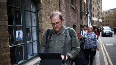 Stuart Murphy works on his iPad as he stands in a queue near Bermondsey, London. Reuters