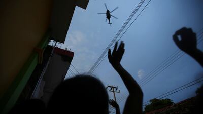 People wave at a helicopter after an earthquake that struck off the southern coast of Mexico. Edgard Garrido / Reuters